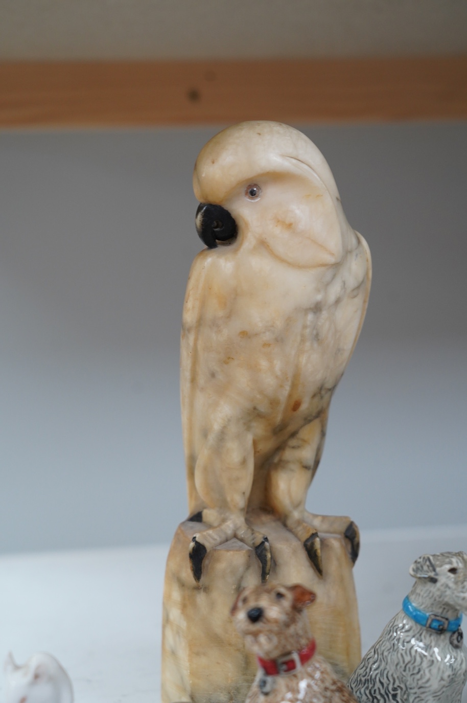 A carved alabaster parrot, a stone carving of two mice, two Royal Copenhagen mice, a mouse spill vase, a pair of dog pepperettes and a hare ornament, tallest 26cm high (8). Condition - small chip to ear of white Copenhag